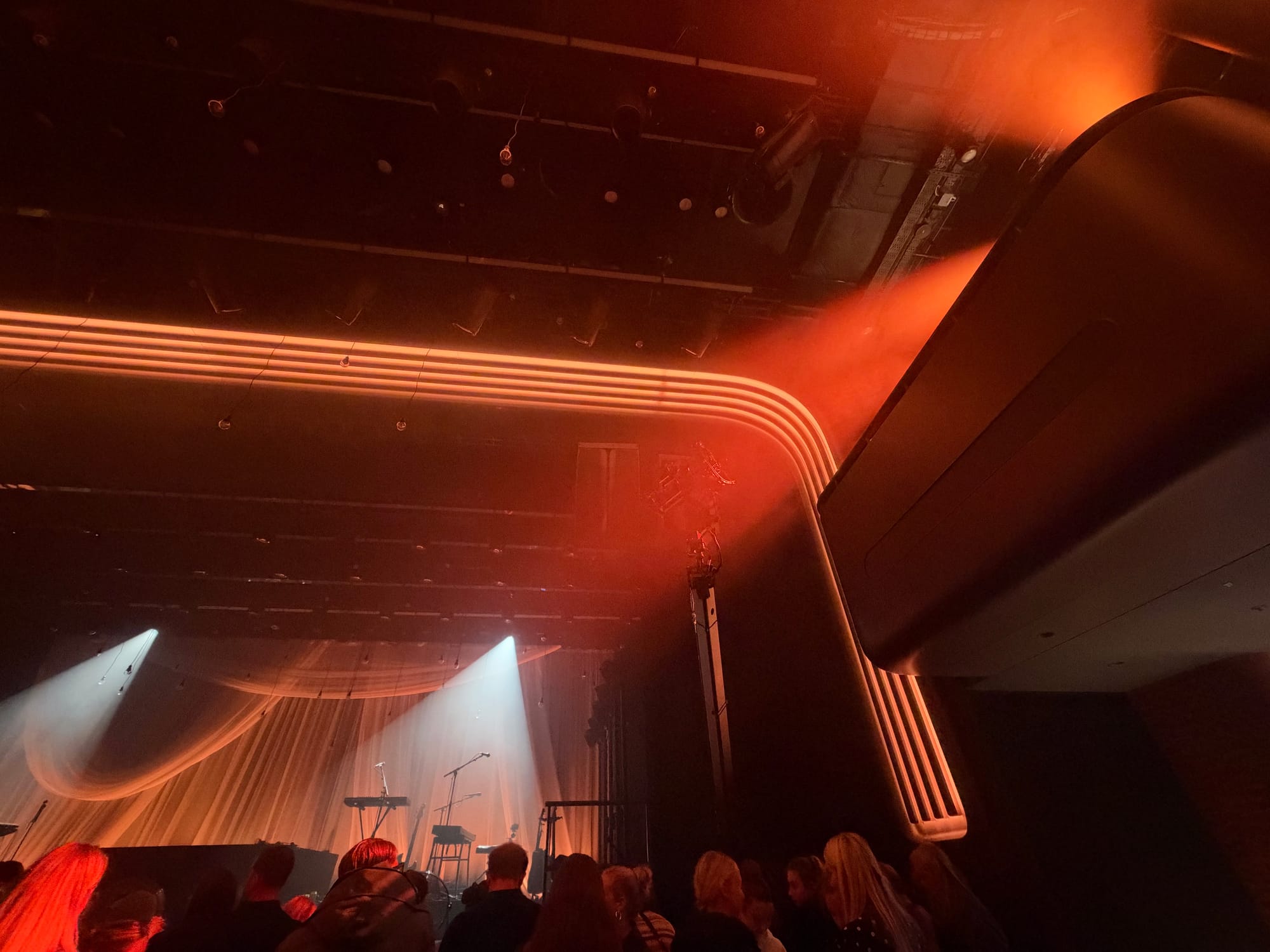 Bright neon rounded lights that stretch from the walls of the venue to the roof. The colours change as the stage lighting changes.